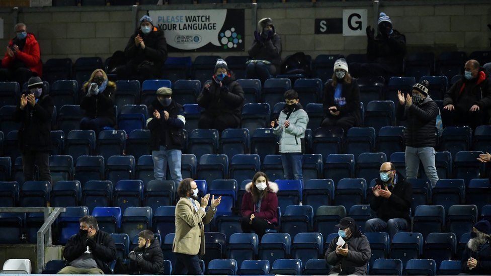 Fans wear protective masks and social distance prior to the Sky Bet Championship match between Wycombe Wanderers and Stoke City at Adams Park