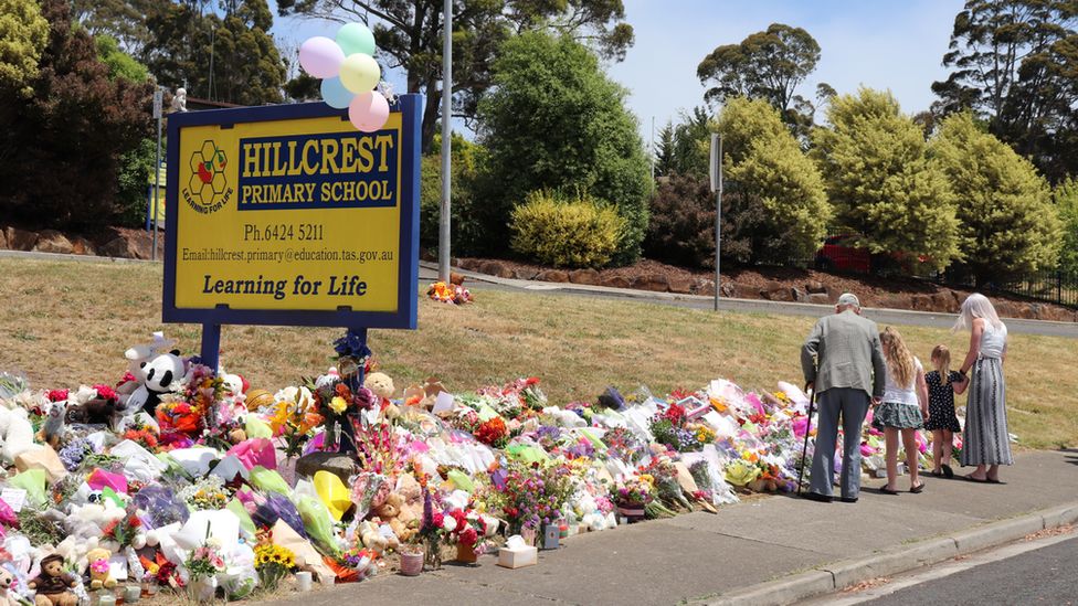 Mourners leave flowers in front of Hillcrest Primary School