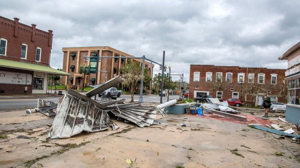 A person walks next to debris in the town of Perry, after Hurricane Idalia made landfall near Keaton Beach, Florida, USA, 30 August 2023. Hurricane Idalia makes landfall in Florida as a Category 3 storm with winds of 125 mph.