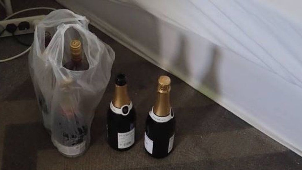 Bottles of champagne next to a bed