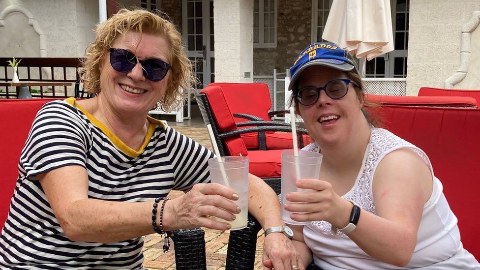 Liz and her daughter on holiday, holding drinks