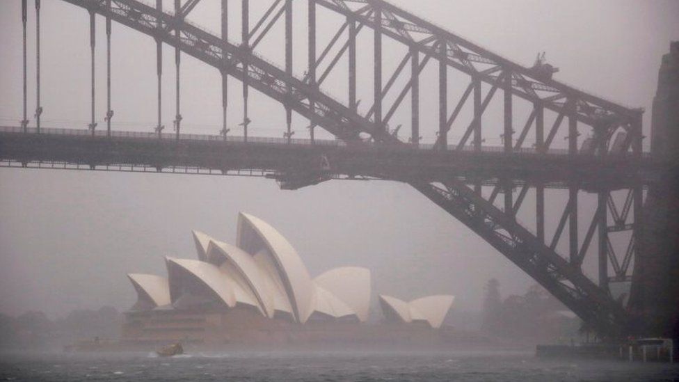 Storms clouds are seen behind the Sydney Opera House and Sydney Harbour Bridge