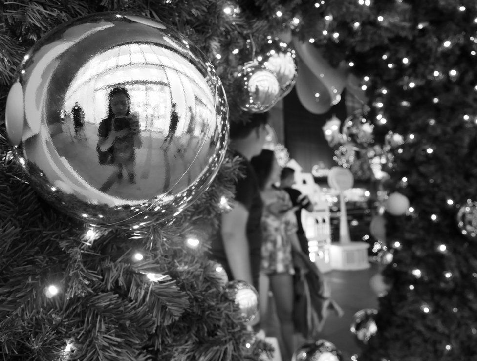 A woman is reflected in a bauble
