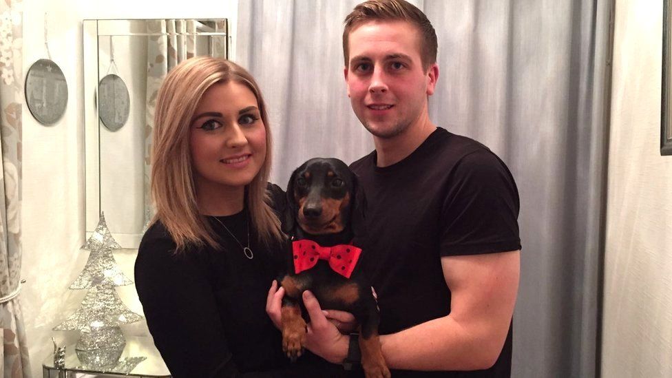 Couple cradling Harley in a bow tie