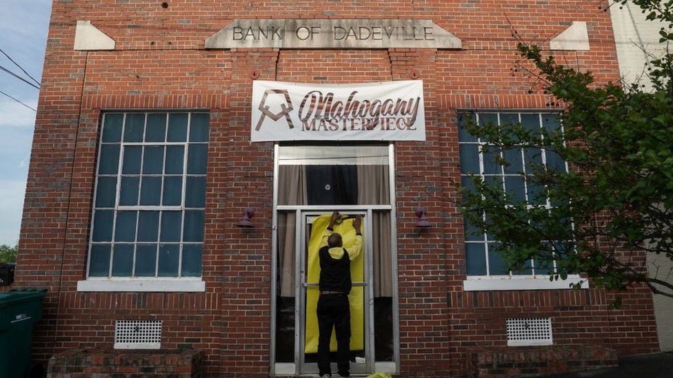 Норман Брукс прикрывает дверь танцевальной студии Mahogany Masterpiece, места массовой стрельбы прошлой ночью, 16 апреля 2023 года в Дадевиле, штат Алабама.