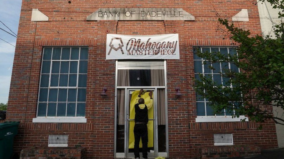 Norman Brooks covers the door of the Mahogany Masterpiece dance studio, the scene of last night's deadly mass shooting, on April 16, 2023 in Dadeville, Alabama.