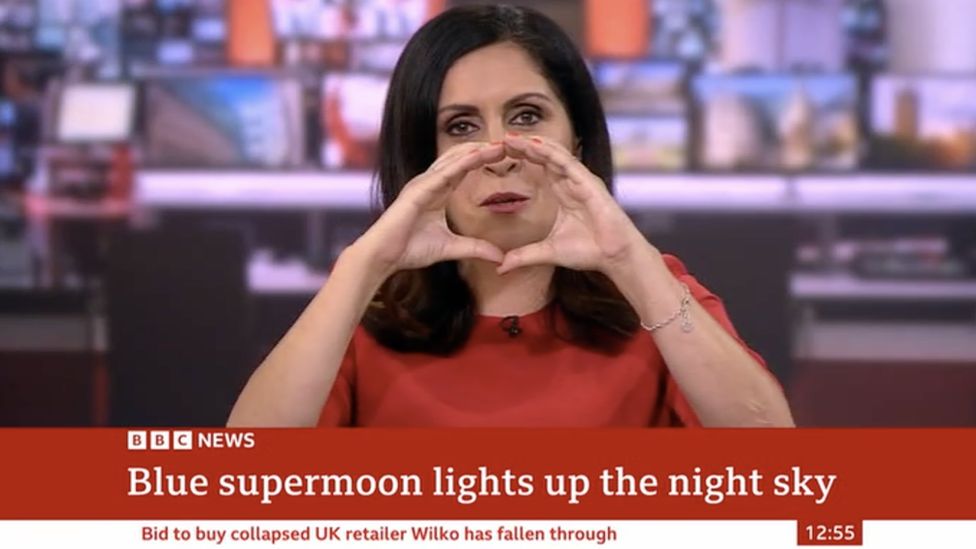 BBC News presenter Maryam Moshiri attempts to recreate the blue supermoon using her hands when pictures fail to appear on screen