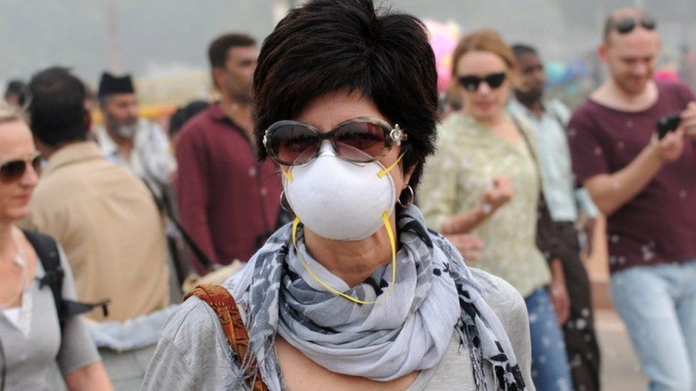 A foreigner wearing an anti-pollution mask walks a street in New Delhi, India, 5 November 2016.