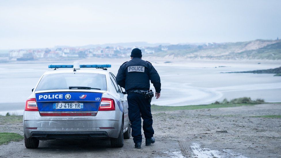 French Police officer looking out over a beach near Wimereux in France