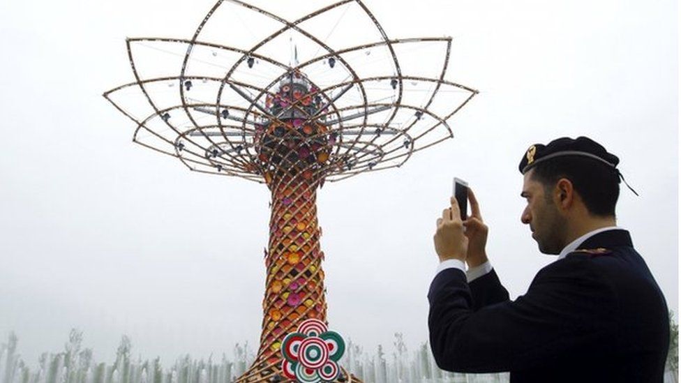 A policeman takes pictures at the "Tree of life" at Expo 2015 in Milan, Italy, 1 May 2015