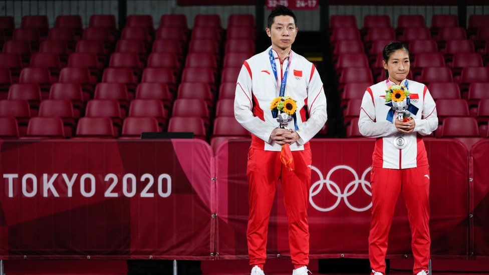 Silver medalists Xu Xin and Liu Shiwen of China pose on the podium after the Mixed Doubles Gold Medal Match against Jun Mizutani and Mima Ito of Japan.
