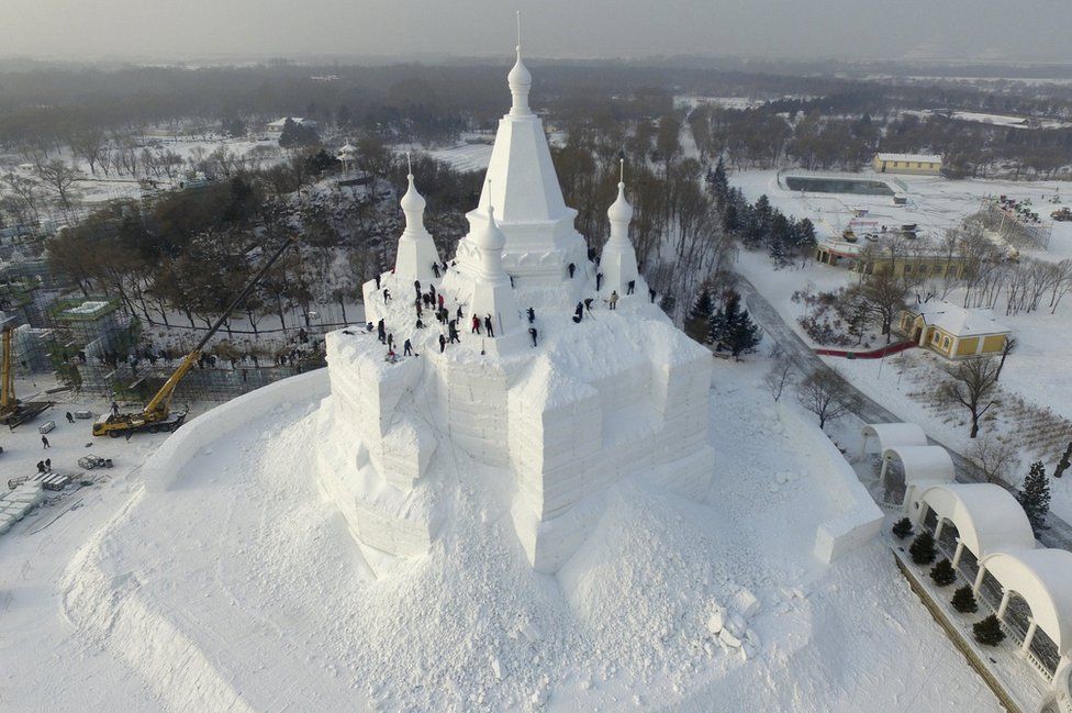 Workers polish a snow sculpture, 23 December 2015