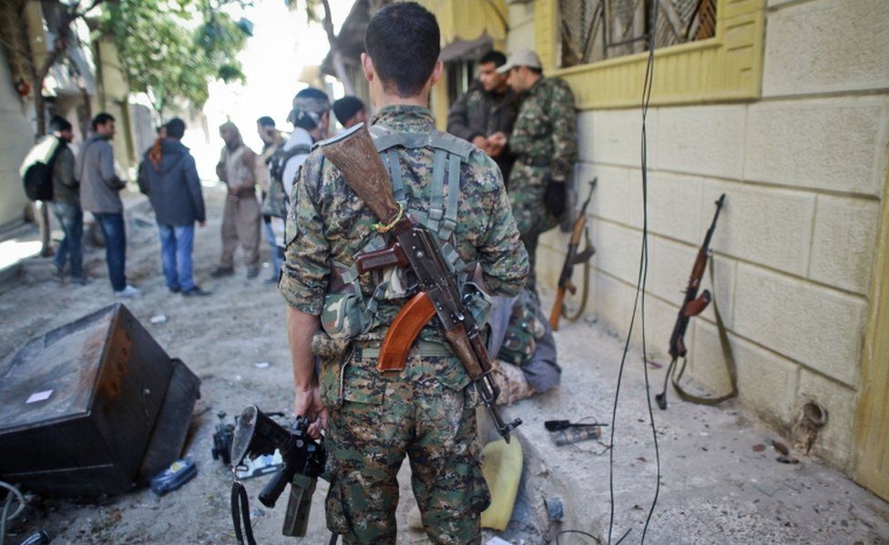 YPG fighters pictured on the street in a besieged Syrian border town in November 2014