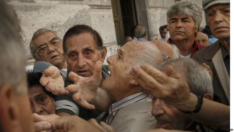 Pensioners try to get a number to enter inside a bank in Athens, Wednesday, July 1, 2015