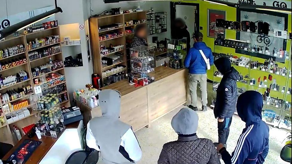 CCTV footage show six alleged armed thieves talking with the shop owner