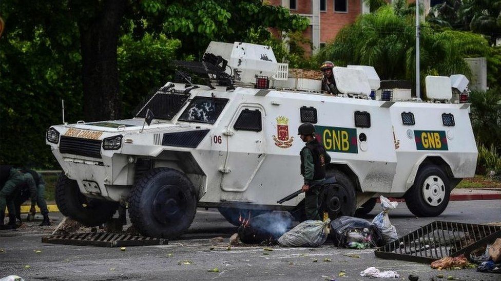 A National Guard vehicle goes through a barricade built by anti-government activists in Venezuela's third city, Valencia, on August 6, 2016,