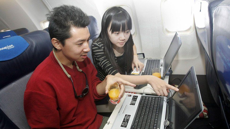 Guests try out the wireless connection to the Internet on their laptops onboard a US aerospace giant Boeing's latest aircraft 'Connexion', which allows passengers to connect on the Internet wireless while flying, at the Beijing Capital airport 21 September 2005.