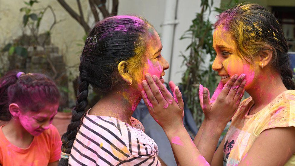 Children applying colours on one another in Delhi