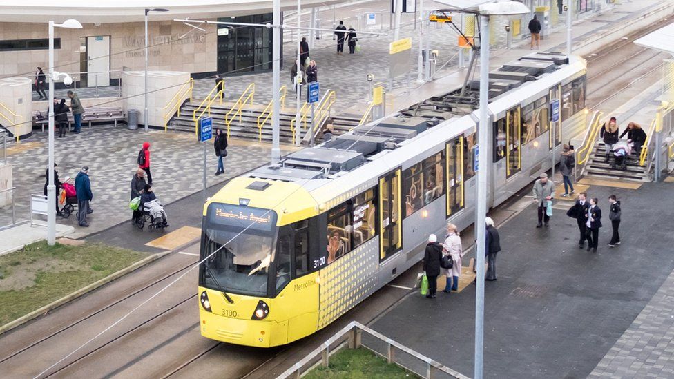 tram at station surrounded by commuters