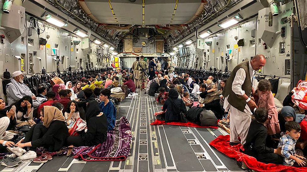 Afghans sit inside a US military aircraft waiting to leave Afghanistan, at the military airport in Kabul - 19 August 2021