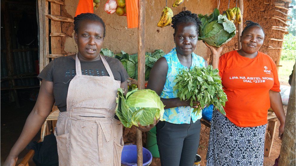 Mama Sasha and her friends showcase cabbages outside her stall in Kosachei