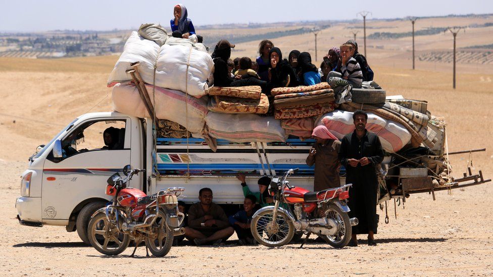 Syrians, who fled the Islamic State (IS) group stronghold of Raqqa, ride with their belongings on a truck, in an area near the village of Balaban, south of Jarablus, Syriaemb