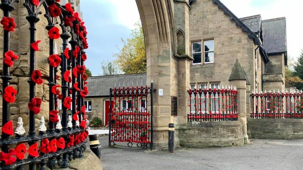 Gates to Hebburn cemetery covered in knitted poppies