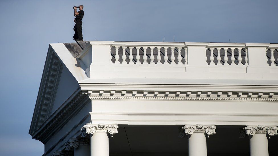 A member of the Secret Service's counter sniper team looks out from the roof of the North Portico of the White House September 7, 2013 in Washington, DC.