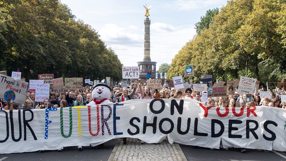 Protesters with a banner "Our future on your shoulders" attend a demonstration at the Victory Column