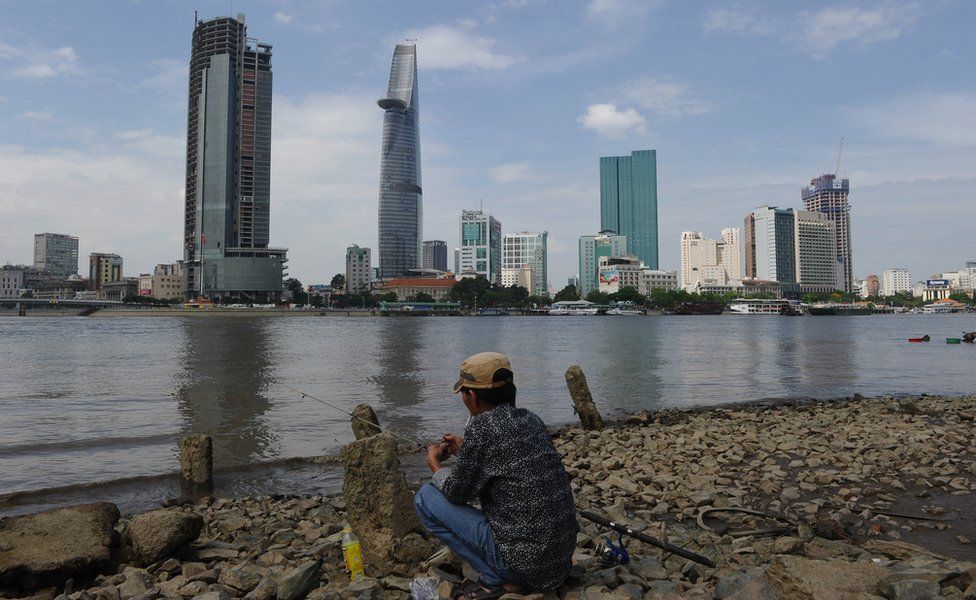 Ho Chi Minh City skyline with man fishing in foreground