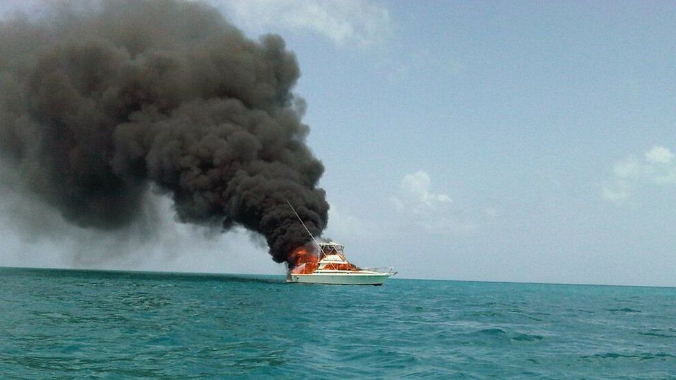 A boat on fire off the shore of Antigua
