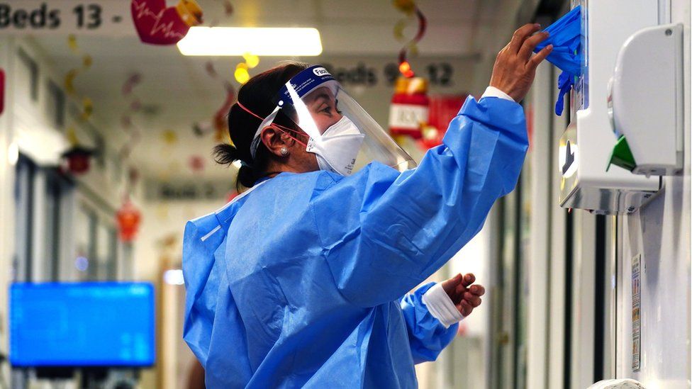 A nurse puts on PPE at King's College Hospital in London