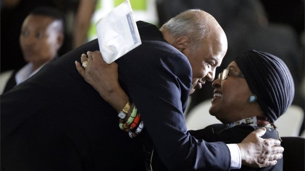 Pravin Gordhan, South Africa's finance minister, left, greets former President Nelson Mandela"s wife, Winnie Madikizela-Mandela, during the funeral service for Ahmed Kathrada, at West Park Cemetery in Johannesburg, South Africa, Wednesday, March 29, 2017.