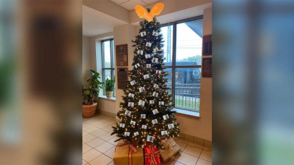 Christmas tree adorned with images of suspects