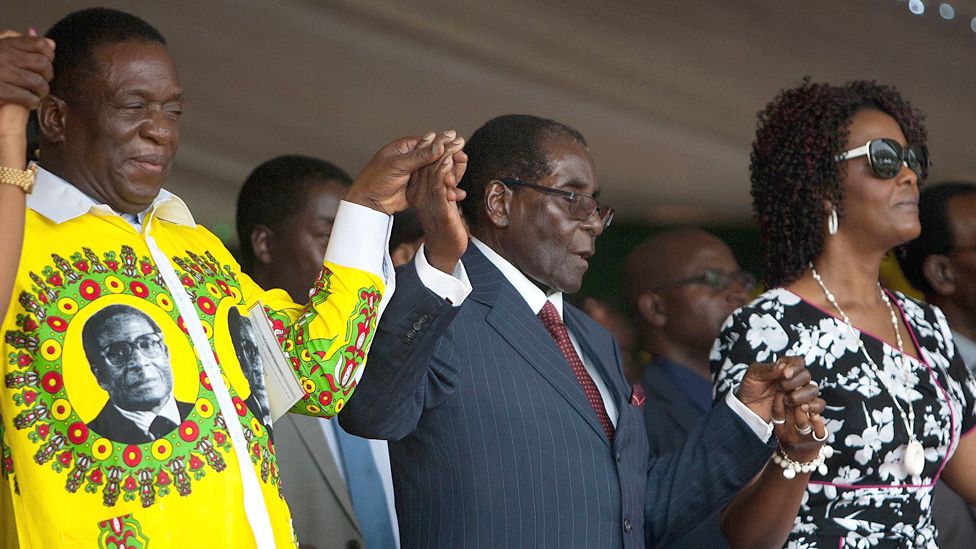 Роберт Мугабе (в центре) держится за руки с Эммерсоном Мнангагвой (слева) и Грейс Мугабе (справа) у памятника Великому Зимбабве в Масвинго, февраль 2016 г.