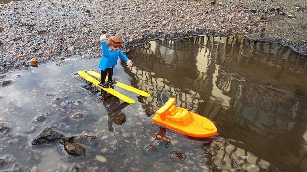 A Lego model on skiis in a pothole