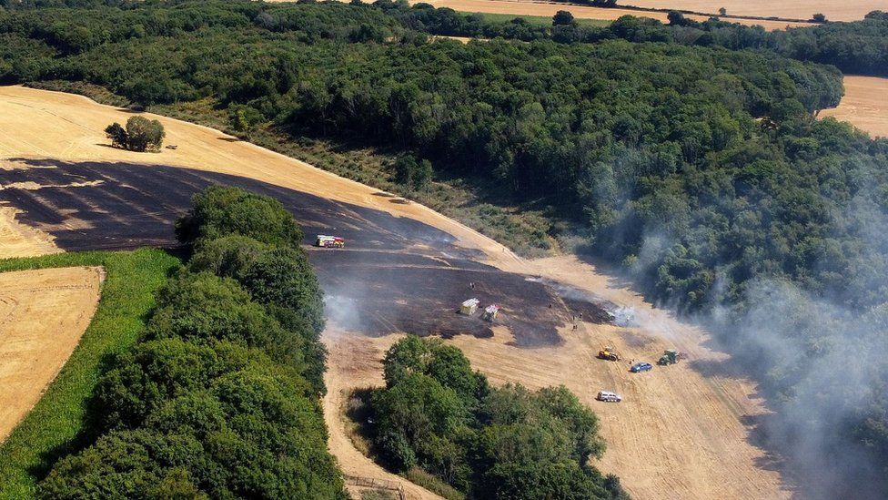 Firefighters bring a field fire under control near Ashford in Kent