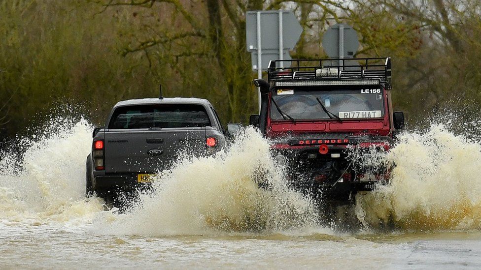 Cars driving through a flooded road