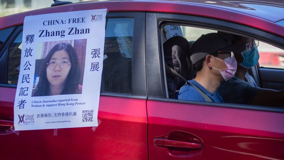A car follows a funeral caravan with poster of Zhang Zhan, a Chinese citizen journalist who criticized the Chinese government's handling of the coronavirus crisis and is being held in a Shanghai prison.