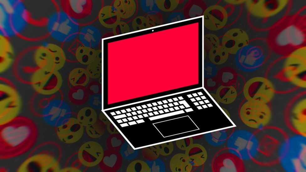 A laptop with a red screen against a background of emojis