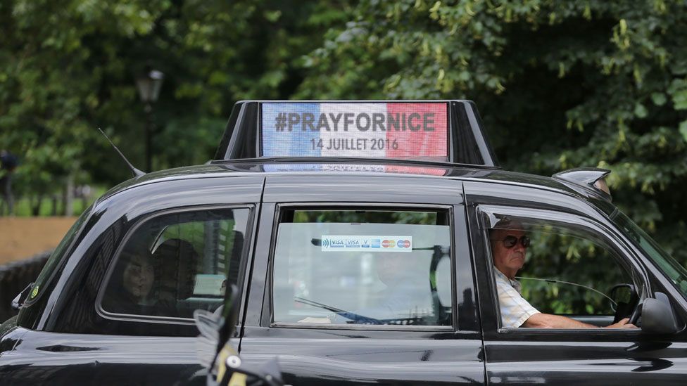 A London taxi carries a sign "Pray for Nice"