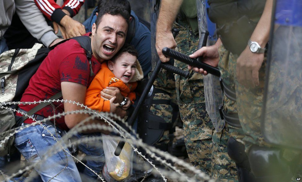 A migrant man and boy blocked by Macedonian police near Idomeni, northern Greece, 21 August 2015