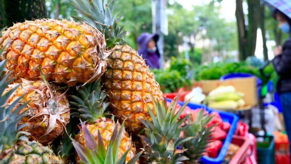 A hawker selling pineapples seen in the street of Taipei