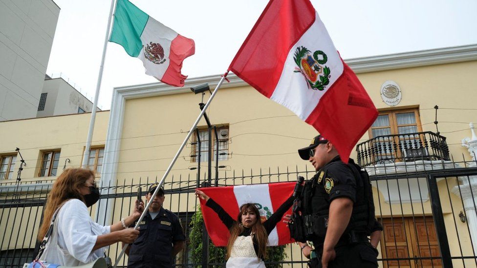 Demonstrators stand outside the Mexican embassy in Lima after Mexico granted asylum to the family of Pedro Castillo