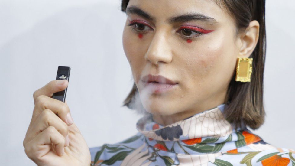 A model smokes a vape before the Snow Xue Gao Spring Summer 2018 show during New York Fashion Week on 8 September 2017 in New York