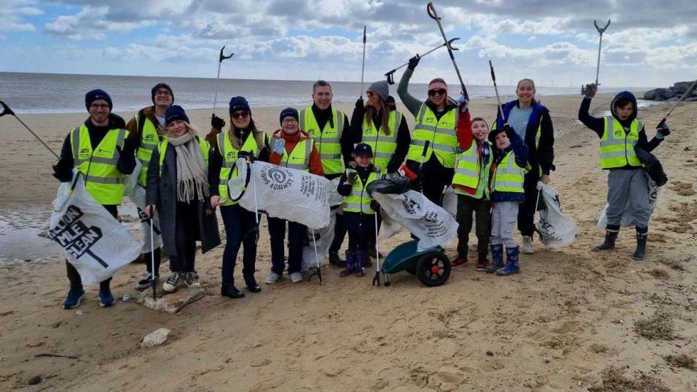 Group of people with bags and grabbers, on a litter pick at Hemsby beach