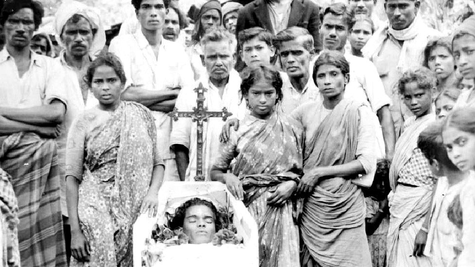 Relatives surrounding a body kept in a casket