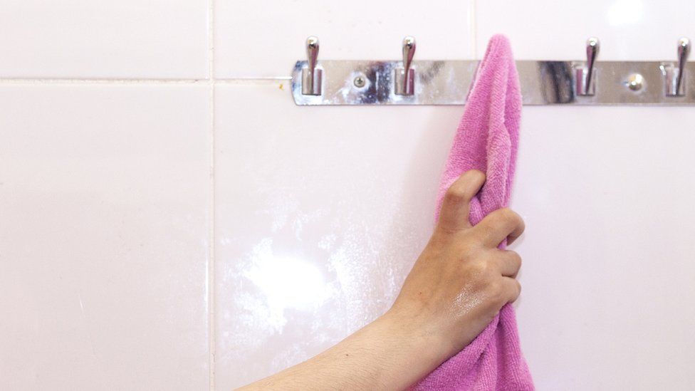 A stock image of a woman reaching for a towel