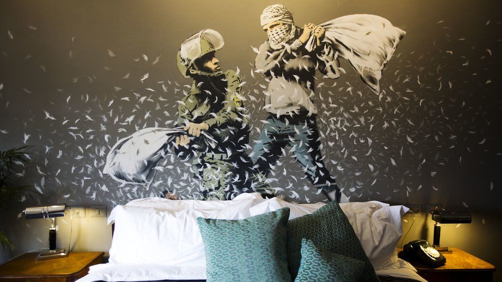 A Banksy wall painting showing Israeli border policeman and Palestinian in a pillow fight is seen in one of the rooms of the "The Walled Off Hotel" in the West Bank city of Bethlehem, Friday, March 3, 2017