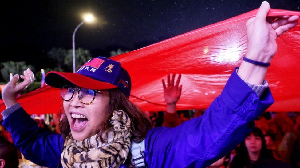 Supporters hoist a giant Taiwan national flag during a campaign rally of Kuomintang (KMT) ahead of Taiwan's presidential election, in Taipei on December 23, 2023.